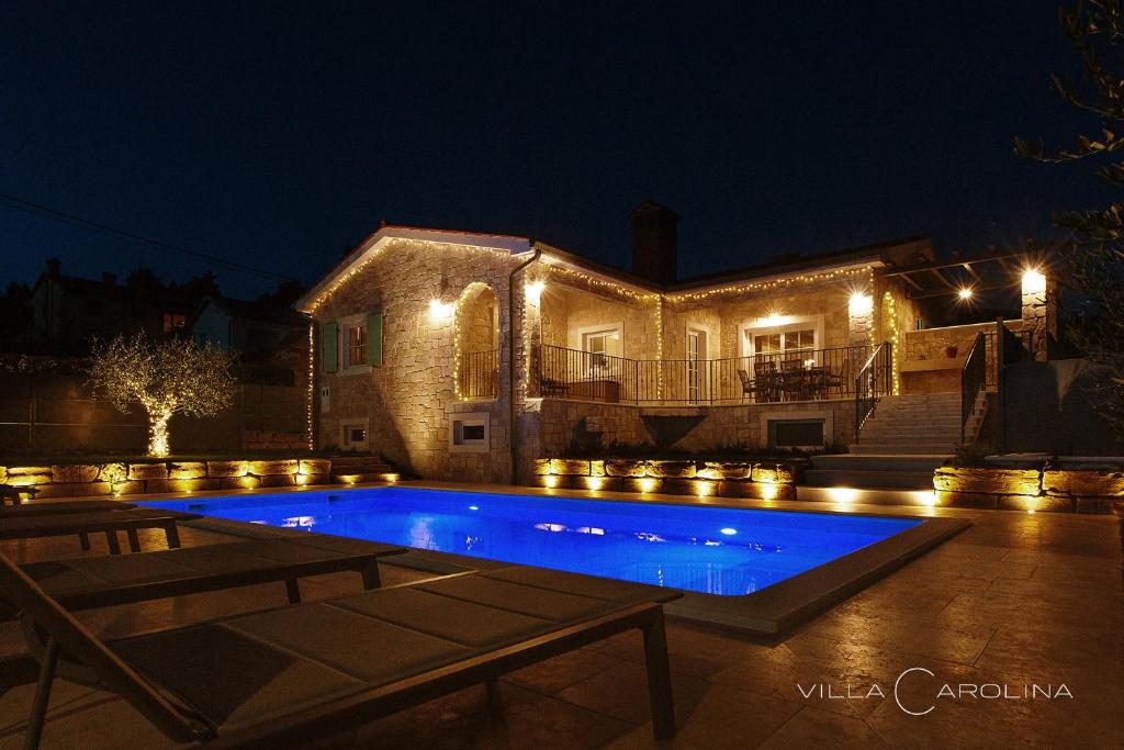 une maison avec piscine la nuit dans l'établissement Villa Carolina, à Izola