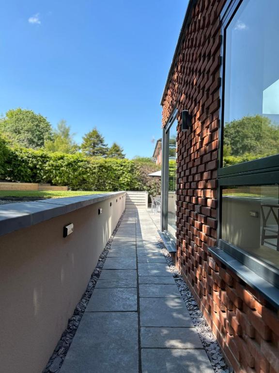 a brick wall and a sidewalk next to a building at Lynwood, 5 bed, 4 bath, private large drive in Bratton