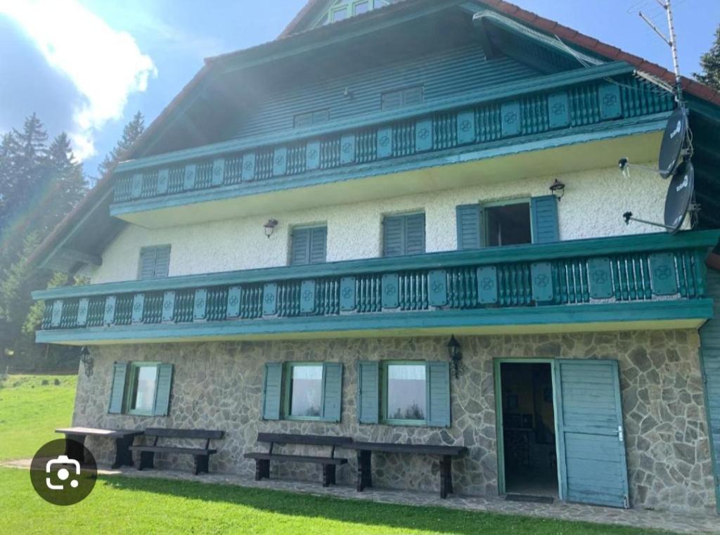 a building with two benches in front of it at Apartma Ajdovka Rogla in Rakovec