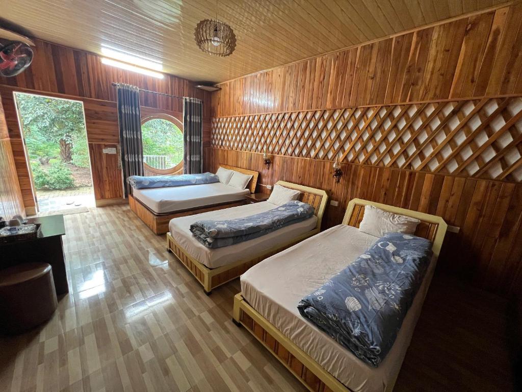 Trang An Maison Retreat في Nguyên Ngoại: سريرين في غرفة ذات جدران خشبية