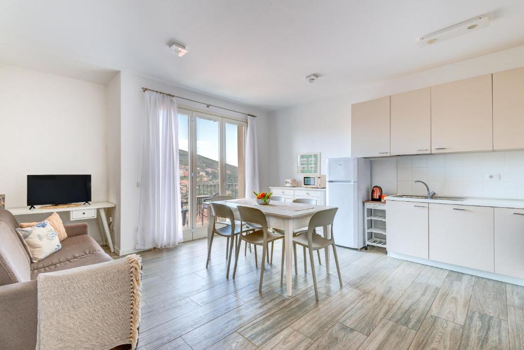 een keuken en woonkamer met een tafel en stoelen bij Appartamento Lucia in Capoliveri