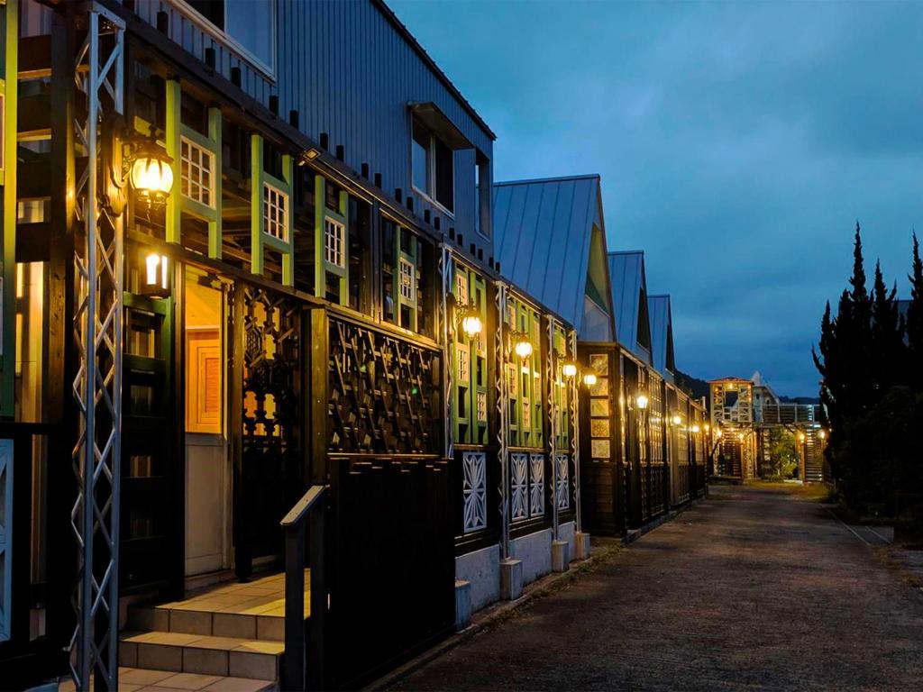 a building with lights on the side of a street at Yufuin Onsen 8A1 Yaeichi in Yufuin