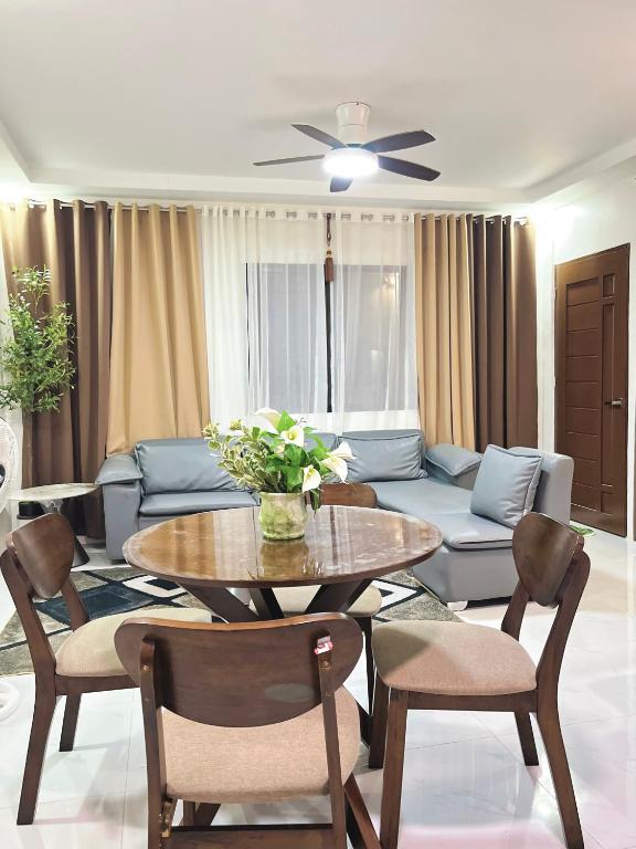 a living room with a table and a couch at Los Glomos RestHub in Los Baños