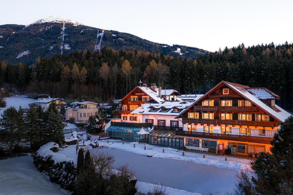un gran edificio en la nieve con una montaña en Hotel Gruberhof Innsbruck Igls B&B, en Innsbruck