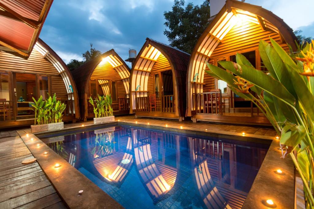 Little Coco Gili Trawangan Hotel في غيلي تراوانغان: فندق فيه مسبح امام مبنى