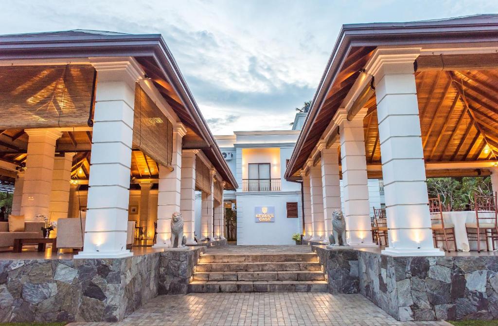 an exterior view of a house with columns at Kevans Casa in Mahiyangana