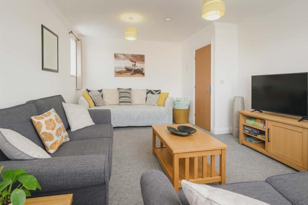 a living room with a couch and a flat screen tv at The Nest at Wynncroft in Torquay