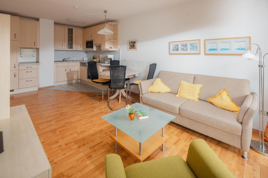 un soggiorno con un divano e un tavolo di Haus Sanderling Meeresbrise a Loog