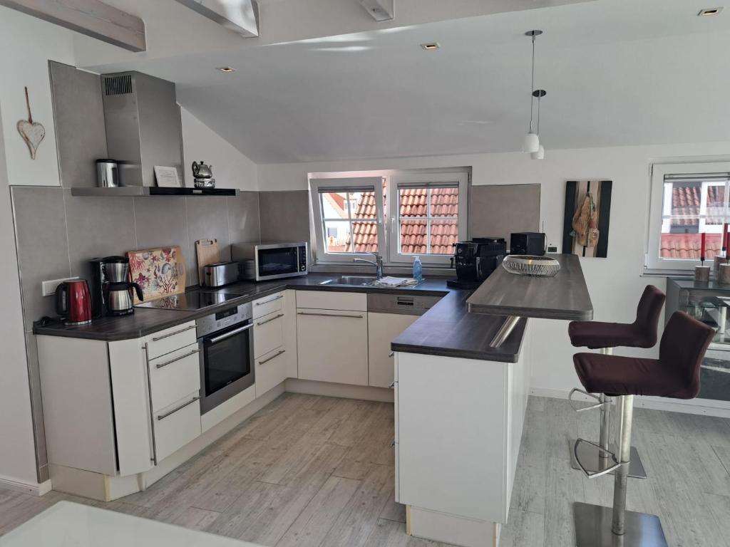 a kitchen with white cabinets and black counter tops at ENA Ferien Strandloft in Juist