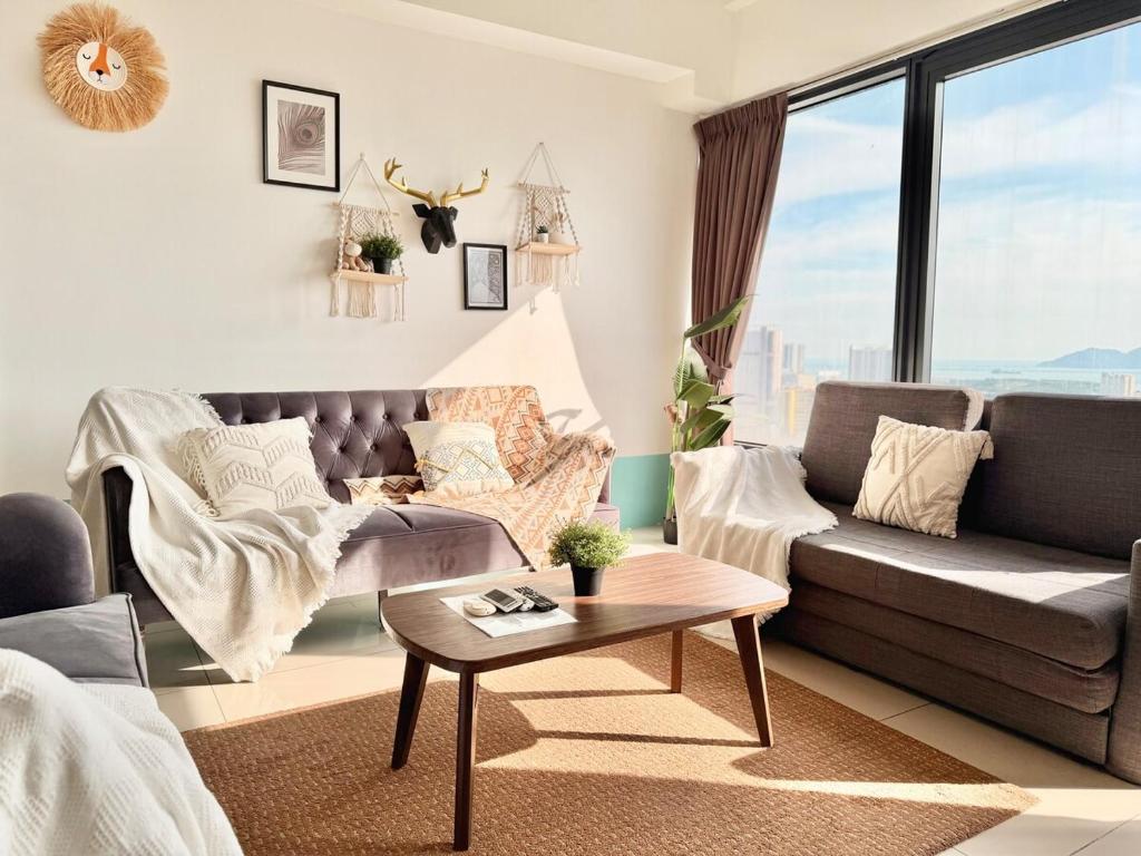 a living room with a couch and a table at Tropicana 218 Macalister #Top Floor #WideAngleViews #InfinityPool #Georgetown #8pax #3BR 2bath #2Queen 4Single #Near island hospital #Quality well maintained #Private host in George Town