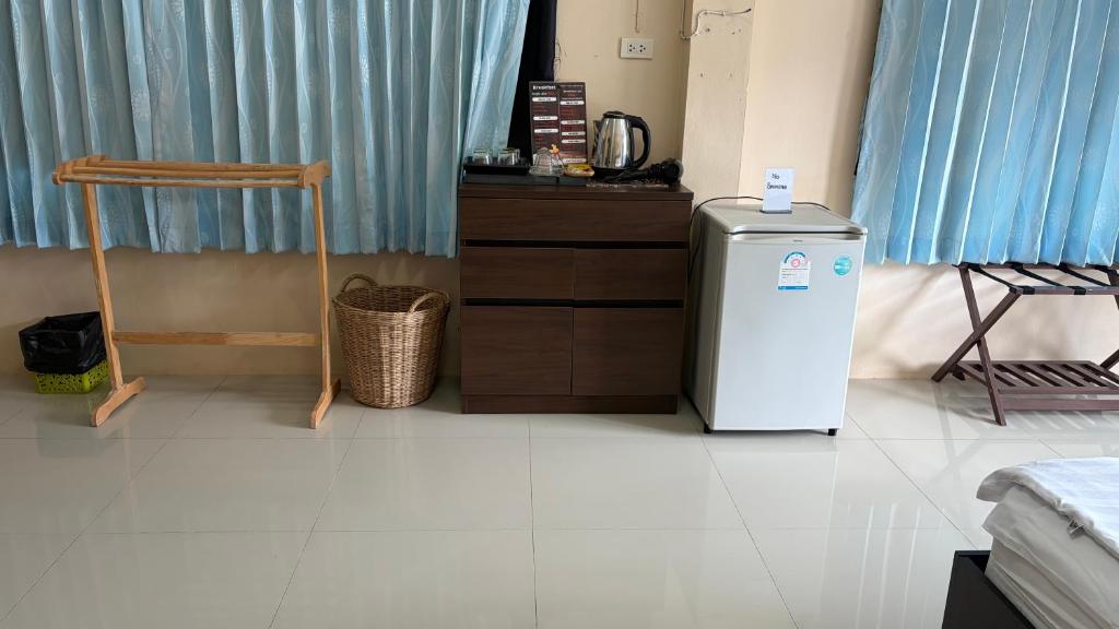 een kamer met een koelkast, een tafel en een stoel bij ChefJa Hotel and Restaurant 