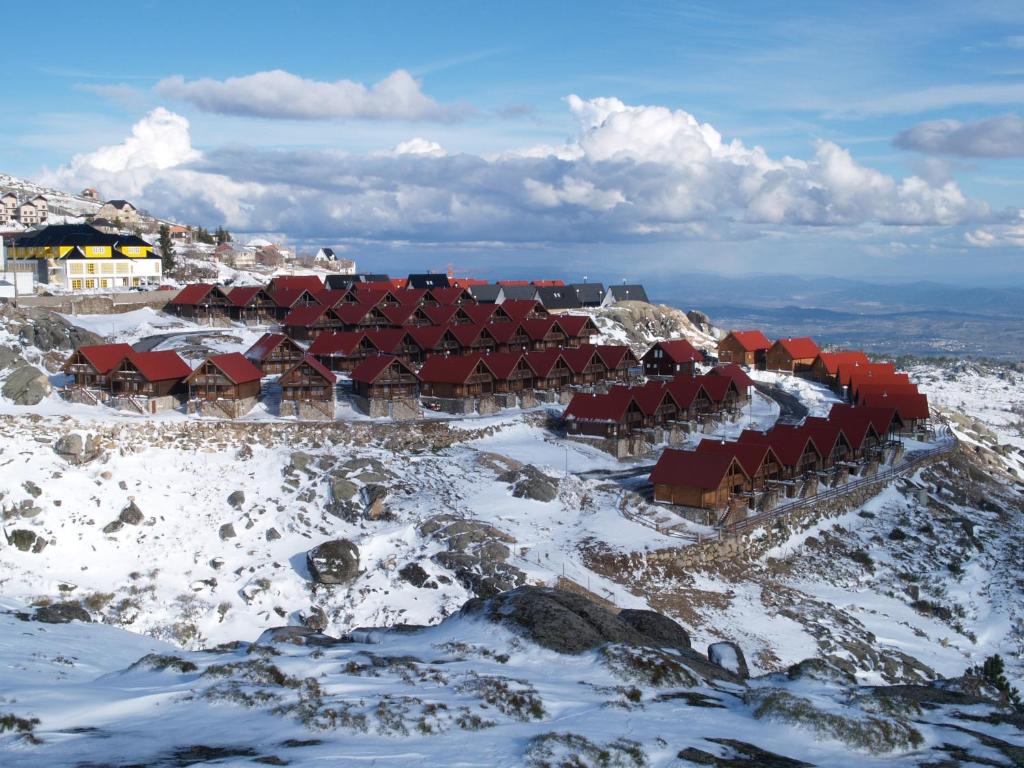 um grupo de edifcios no topo de uma montanha coberta de neve em Luna Chalets da Montanha - Serra da Estrela na Covilh