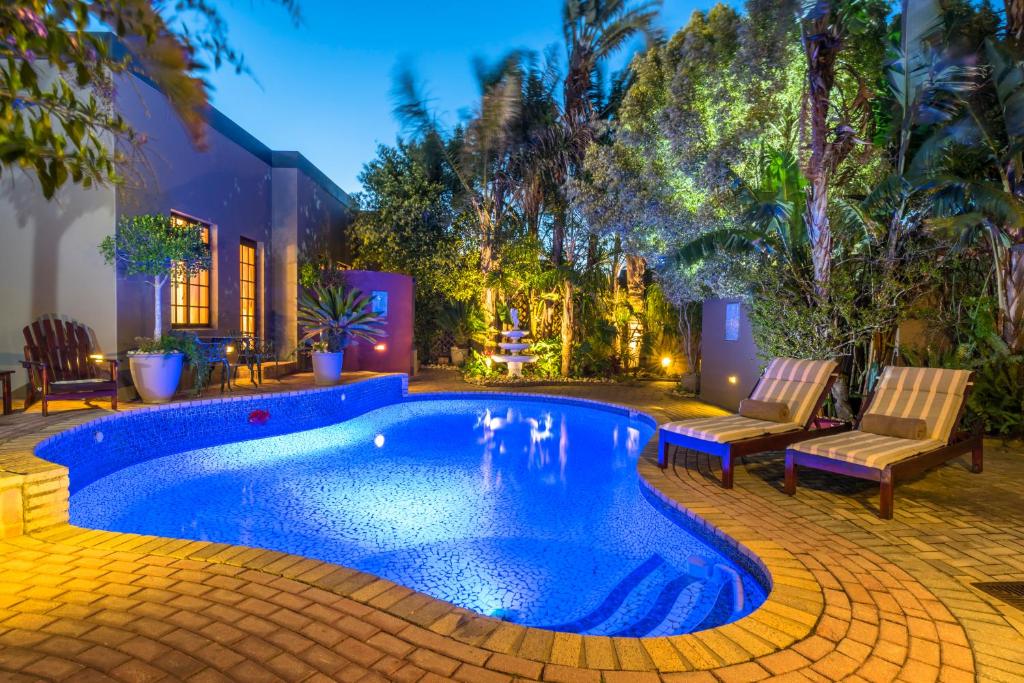 a swimming pool in the middle of a yard at Kingfisher GuestHouse in Port Elizabeth