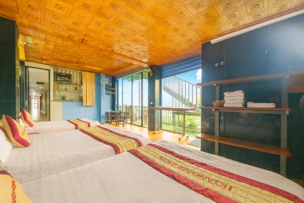Hoàng Hà Hotel Tam Đảo في تام داو: غرفة نوم بها اربعة اسرة ونافذة كبيرة