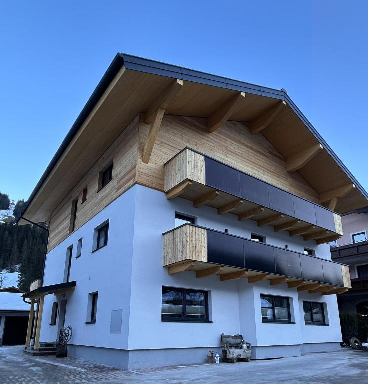 a white building with wooden balconies on it at Höller's Bergleben in Kleinarl