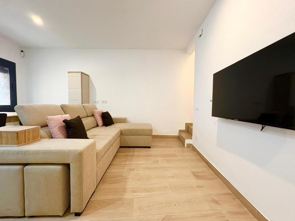 a living room with a couch and a flat screen tv at Hauzify I Can Xasil in Blanes