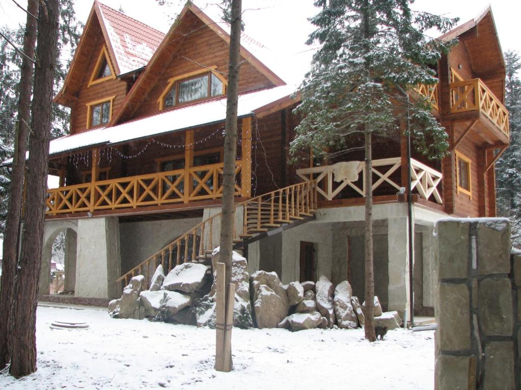 uma grande casa de madeira na floresta na neve em On Dovbush Path em Yaremche