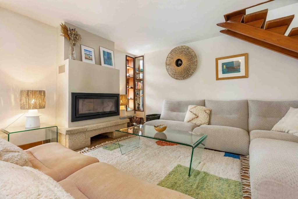 een woonkamer met een bank en een open haard bij Beautiful air-conditioned house and heated pool in La Celle-sous-Gouzon