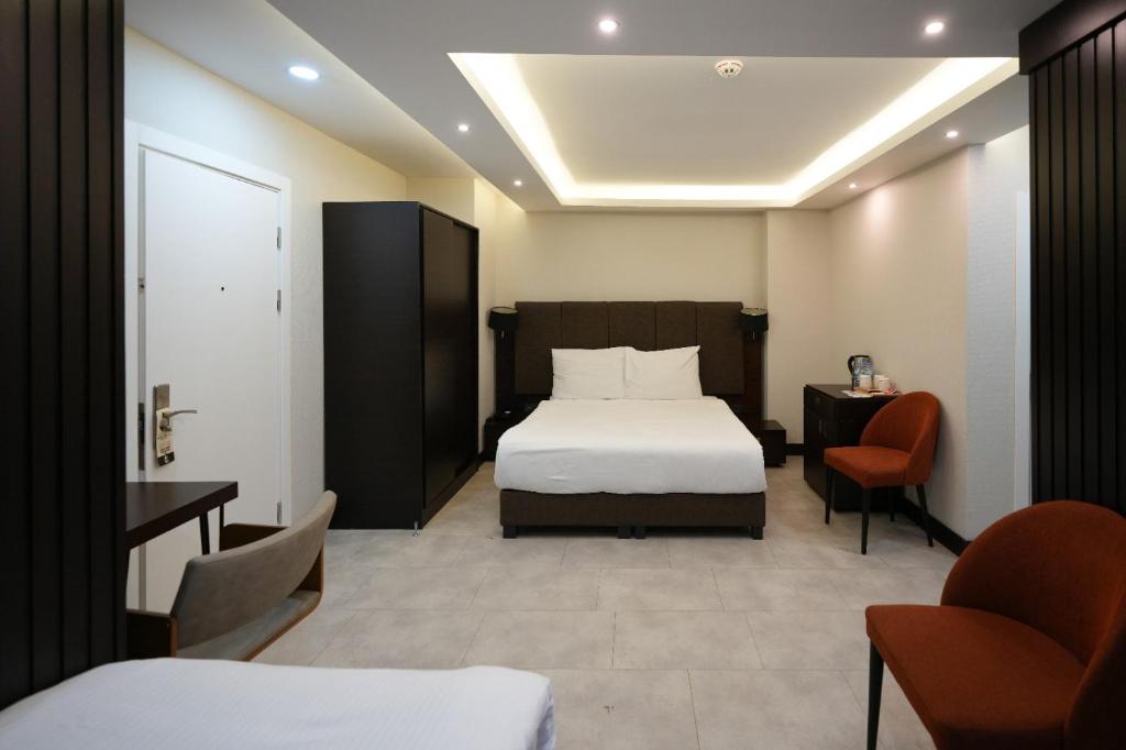 a hotel room with a bed and a desk and chairs at Visse Hotel in Mudanya