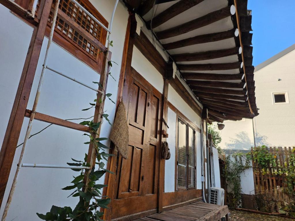 an entrance to a house with a wooden door at 서라벌옛집 in Samgong