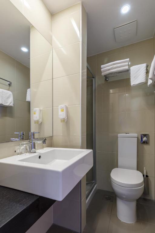 a bathroom with a white sink and a toilet at Hotel Zorna Plava Laguna in Poreč