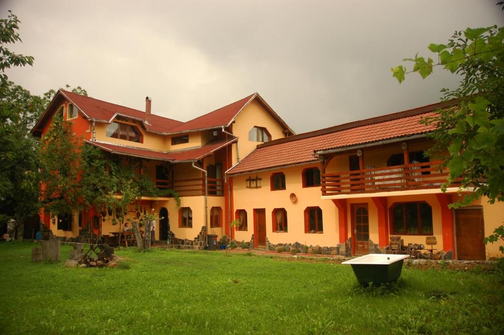 una casa grande con un patio verde delante de ella en Arts and Crafts Guesthouse, en Baia-Sprie