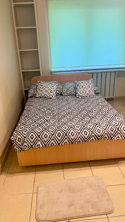 een bed met kussens en een tapijt in een kamer bij Makowa 2 Street in Konin