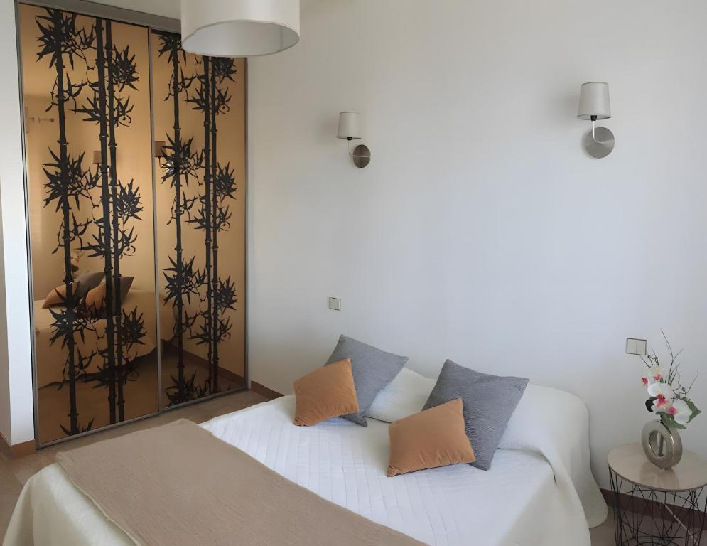 ein weißes Sofa mit Kissen darauf im Zimmer in der Unterkunft Gîtes Villa Beau Soleil Agde in Agde