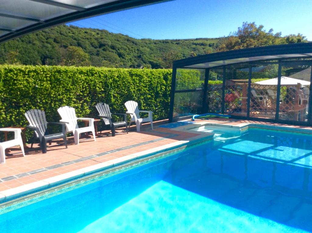 WE ARE UNIQUE ! 4 min walk to Beach, Pubs, Restaurants, Shops, Htd Pool, Hottub, Games rm, 1 acre Garden, BBQ, Stunning walks, Historic Bassets acre, 6 x 1-3 bedroom Superior aparts, Free Parking and WIFI في برتريث: مسبح وكراسي وطاولة بجانب