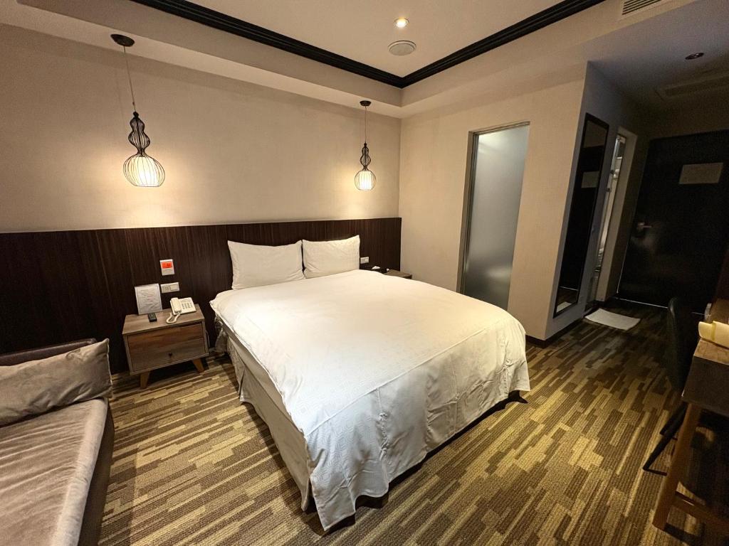 a bedroom with a large white bed in a room at Grace Hotel in Taipei