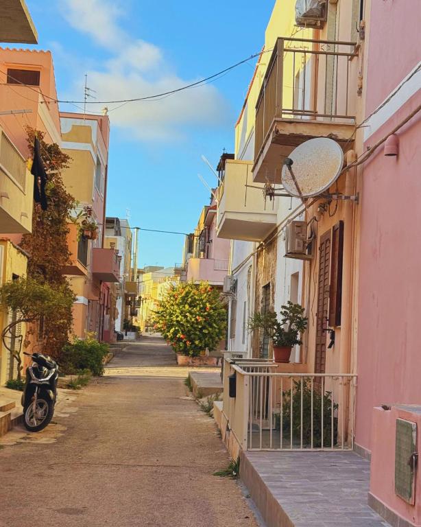 an alley in a city with a motorcycle parked on the street at GC Petit Palais Lampedusa in Lampedusa