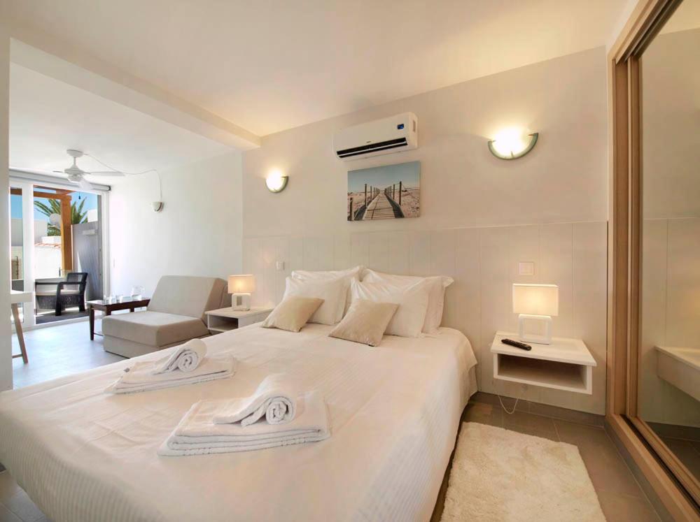 a bedroom with a large white bed with towels on it at Calheta 25 in Luz