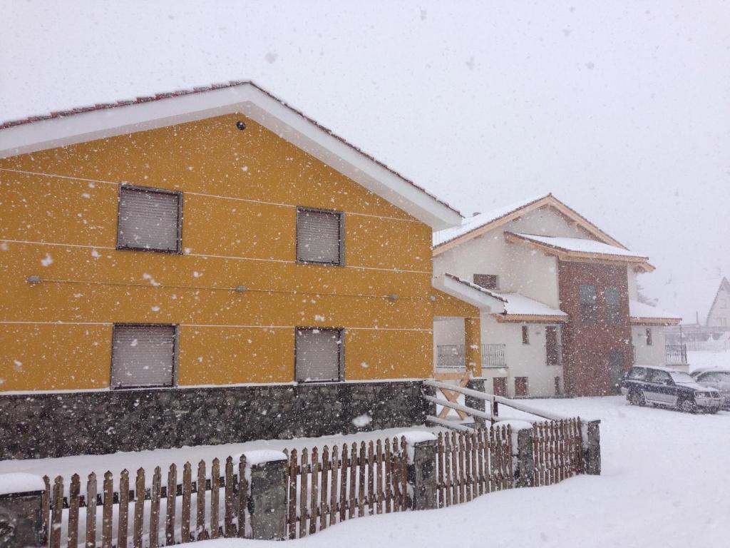 a house covered in snow in a yard at Hotel La Braña in San Isidro