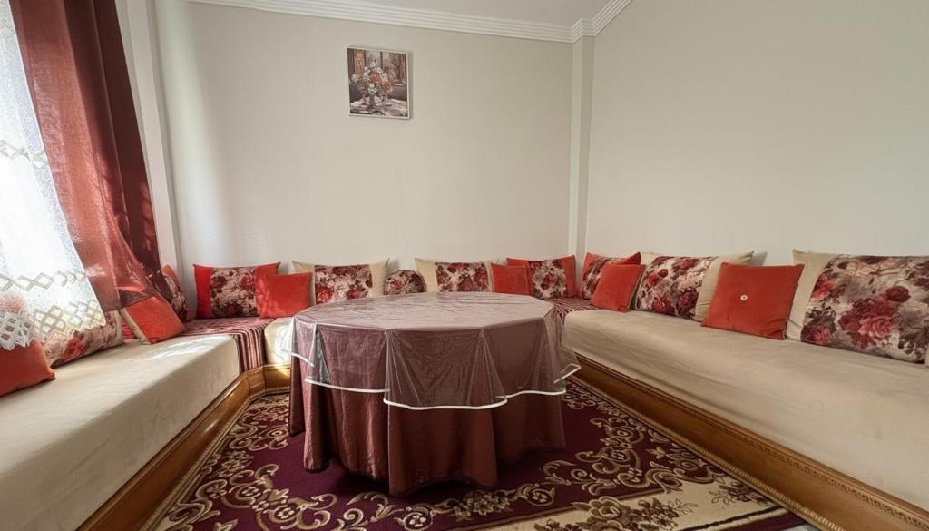a room with a table and couches and a window at Maison Luxueux et Spacieux in Oujda