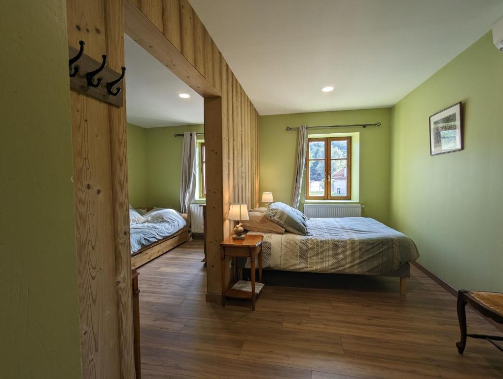 a bedroom with two beds and a window at Chambre familiale, Les Brimbelles in Rehaupal