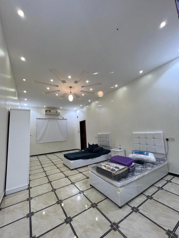 una camera con due letti su un pavimento piastrellato di العلا- العذيب a Madain Saleh