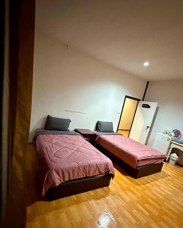 twee bedden in een kamer met houten vloeren bij Light Worker Guest House room number 0 in Phra Ae beach