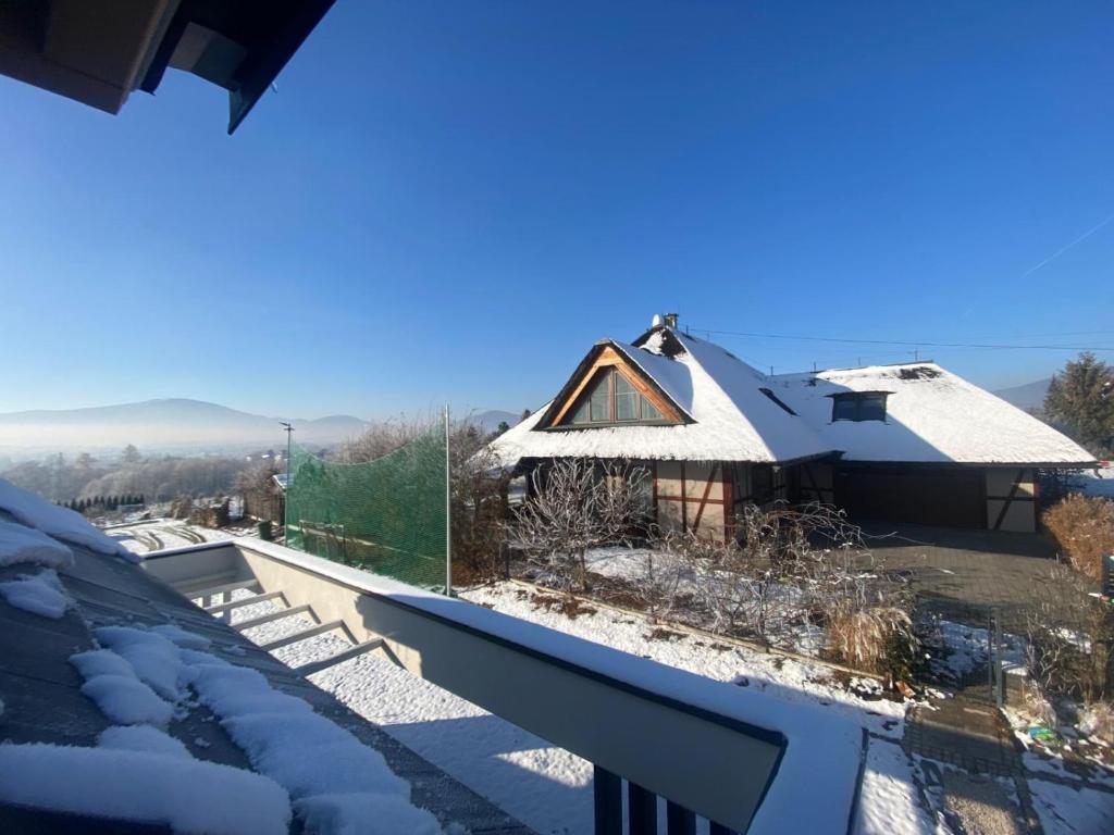 Chata pod strzechą w Beskidach في Bierna: منزل به ثلج على السطح