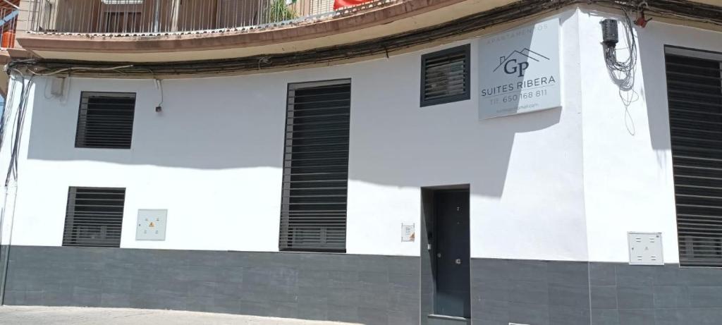 a white building with black shutters on it at Ribera Suites GP in Córdoba