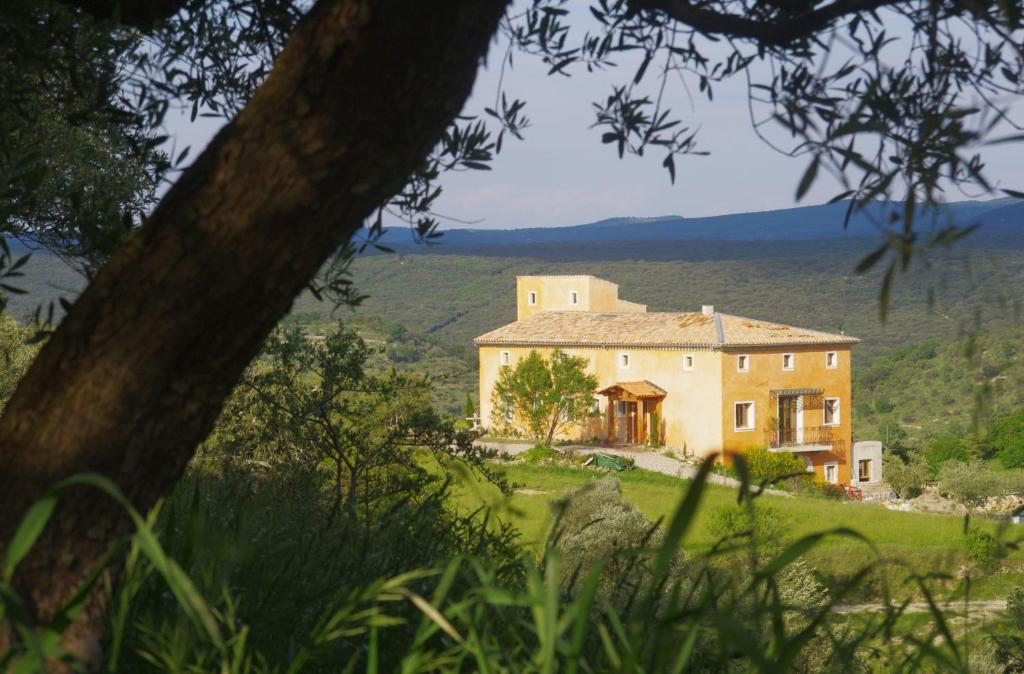 a large house on a hill in a field at Pontet-Fronzèle agrotourisme ecologique, maison d'hôtes & Spa in Lagorce