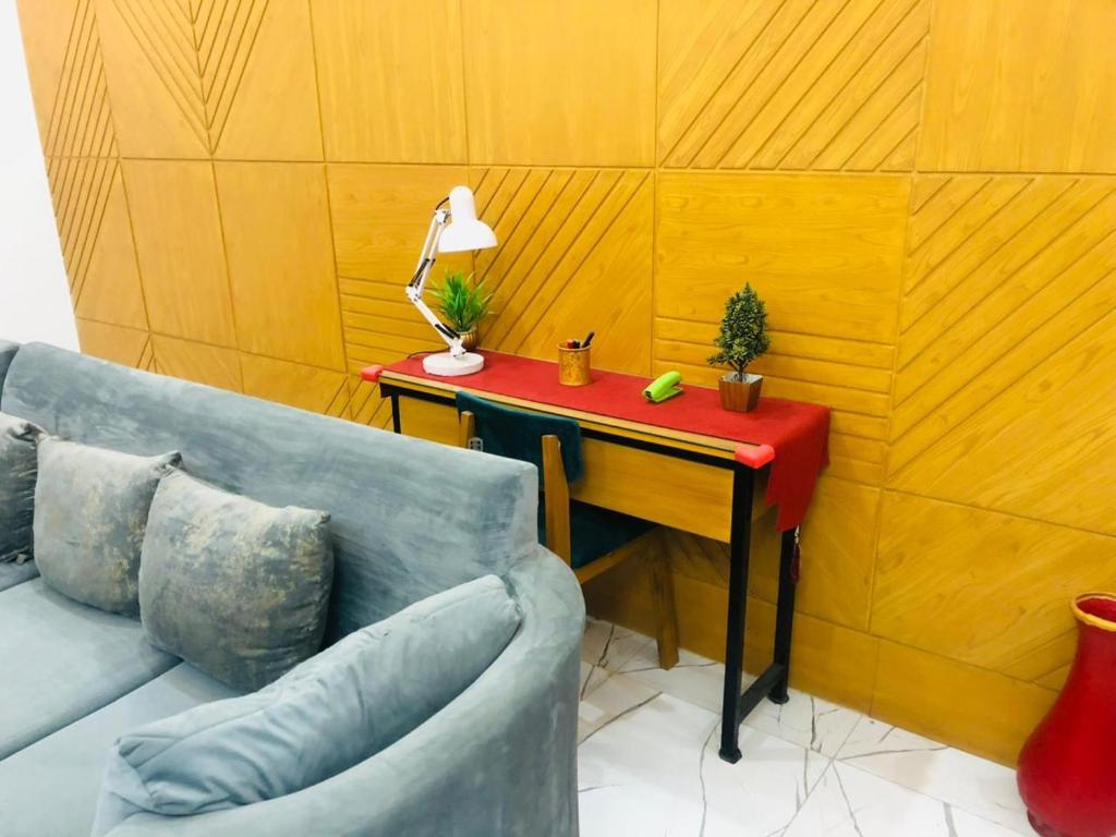 een kamer met een tafel met een bank en een rode tafel sidx sidx bij Luxury Manzil in Lahore