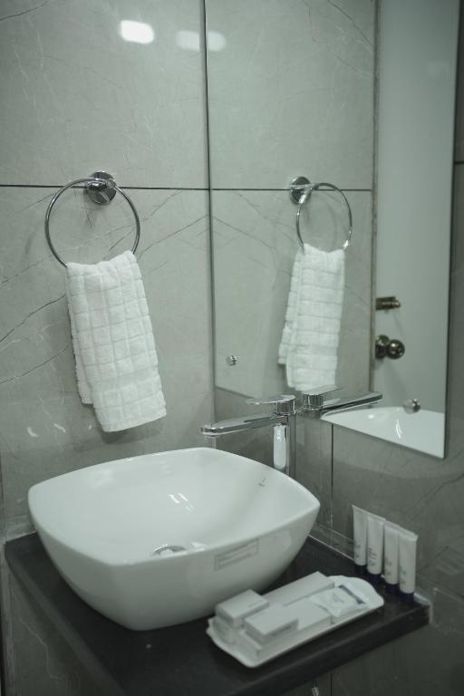Un baño con un lavabo blanco y un espejo. en High Five Hotels, en Assagao