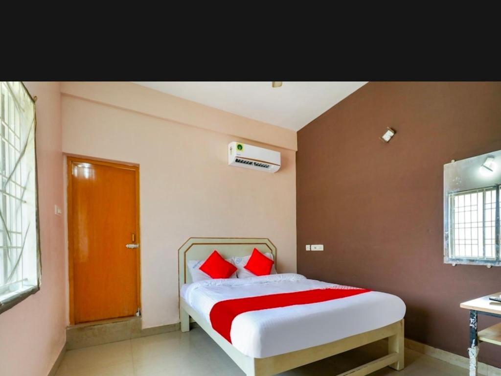 a bedroom with a large bed with red pillows at Hotel RJ Madurai in Madurai