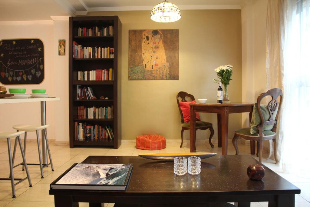 sala de estar con mesa, sillas y estante para libros en Tiffany's Apartment, en Las Palmas de Gran Canaria