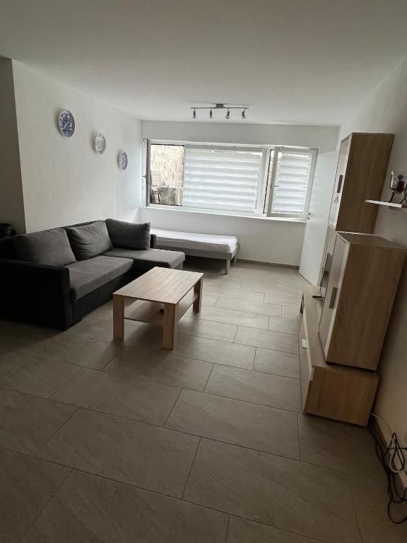 a living room with a couch and a table at FK1 Moderne 75qm 2 Zimmer Einliegerwohnung in Königsbronn
