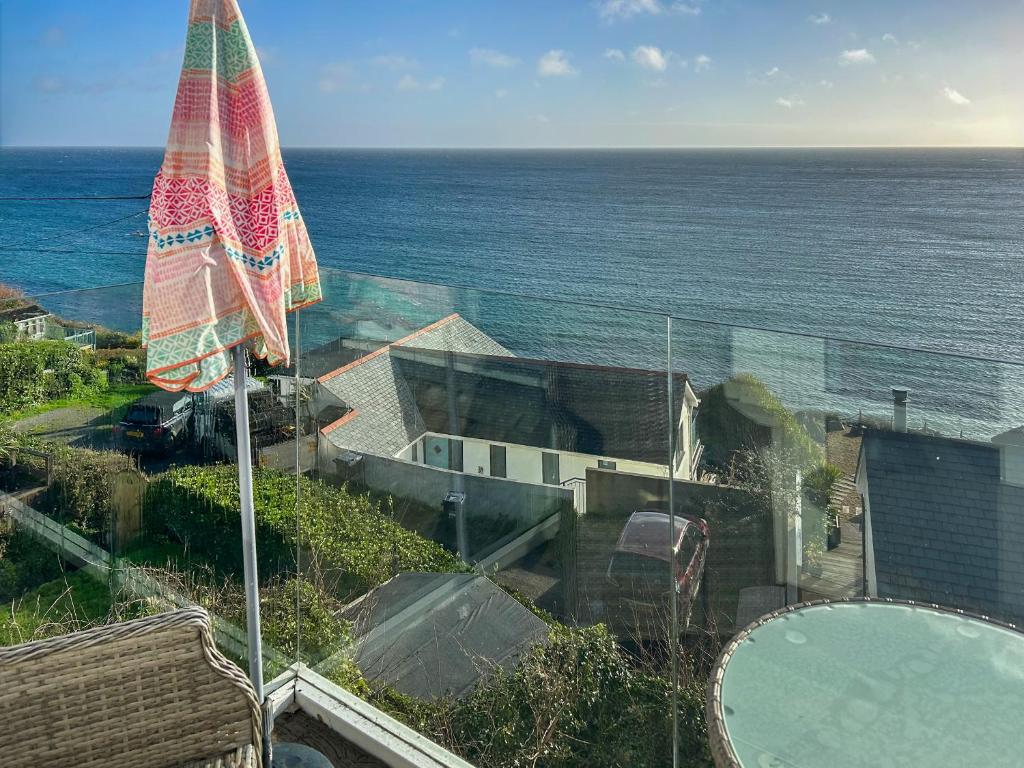 a view of a house with an umbrella and the ocean at The Anchorage in Coverack