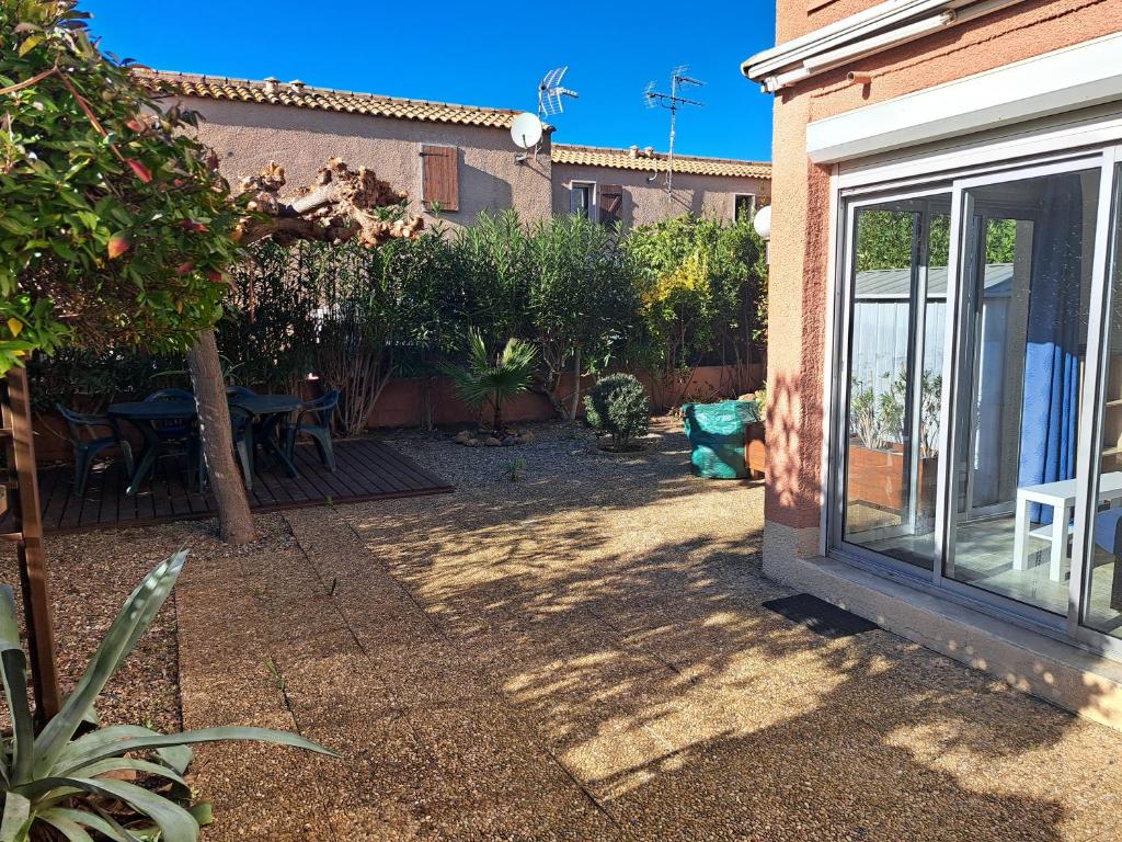 un patio con tavolo e sedie in un cortile di Joli t2 valras plage a Valras-Plage