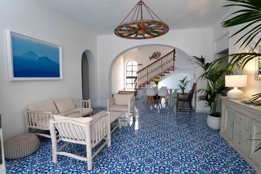 Una sala de estar con escalera, sillas y una mesa en Pietra Pomice Hotel, en Lipari