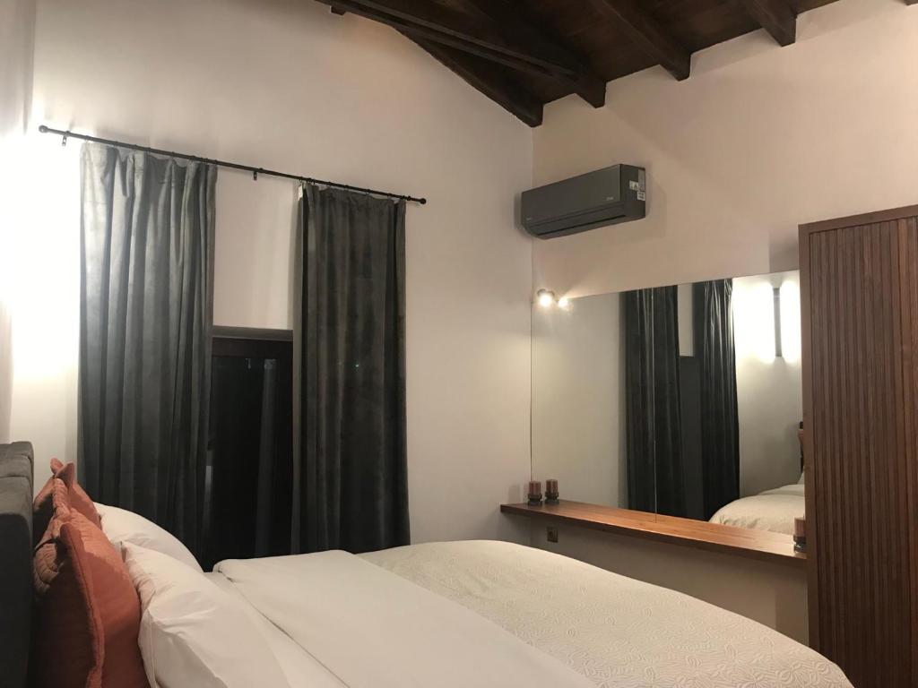 um quarto com 2 camas, um espelho e cortinas em Evanthia maisonette em Chalkida