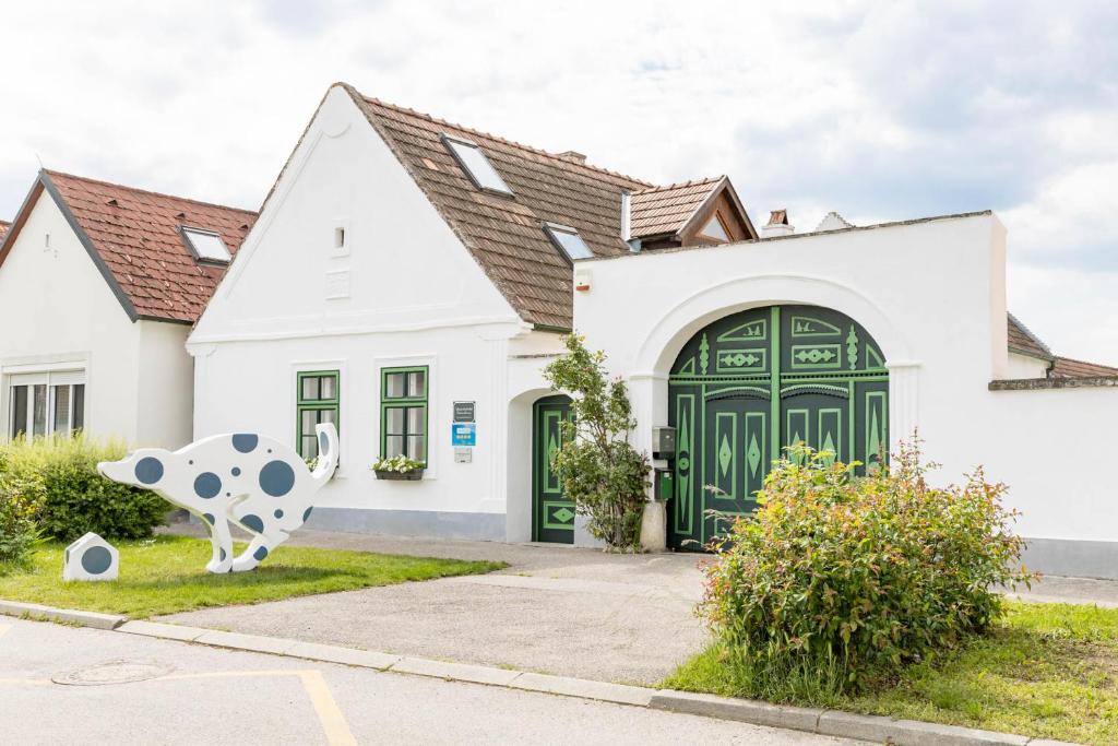 a house with a cow statue in front of it at Weissenbacherhof in Oslip